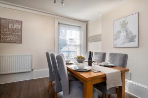 a dining room with a wooden table and chairs at Castle View Townhouse in Conwy