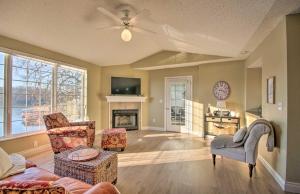a living room with two chairs and a fireplace at Waterfront Townhome with Private Dock and Lake Views in Lake Ozark