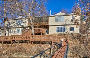 a house with a wooden deck in front of it at Waterfront Townhome with Private Dock and Lake Views in Lake Ozark