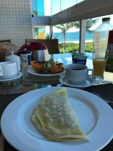 a omelet on a white plate on a table at 4 ILHAS, 2 SUITES, 2 GARAGENS in Bombinhas