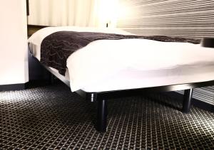 a bedroom with a large bed with white sheets at APA Hotel Yodoyabashi Kitahama Ekimae in Osaka