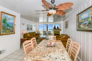 een eetkamer met een tafel met stoelen en een plafondventilator bij E20 - Tropical Paradise - On-the-Sand in Oceanside