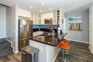 a kitchen with a sink and a refrigerator at B301 - Seaclusion - On-the-Sand in Oceanside