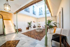 een grote lobby met een groot raam en een bad met planten bij Hotel Madinat in Córdoba