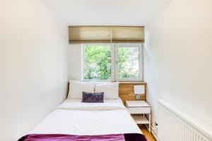 a small bedroom with a bed and a window at Homely 4 Bedroom House in Brixton in London