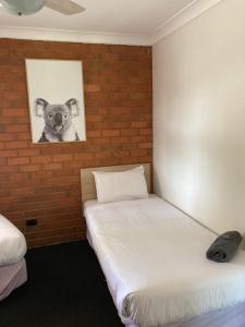 a bedroom with a bed and a painting on the wall at Berrigan Motel in Berrigan