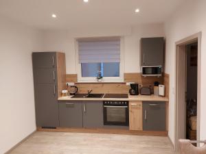 a kitchen with gray cabinets and a window and a sink at Ferienwohnung Popp in Erzhausen