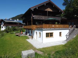 a large house with a deck on top of a yard at Ferienwohnung Mariedei in Berchtesgaden