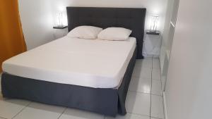 a bed with two pillows on it in a room at THE ISLAND PARADISE in Baillif +35 photos