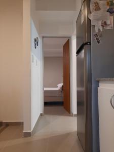 um corredor com um frigorífico e um quarto com uma cama em Via Almafuerte em Concepción del Uruguay