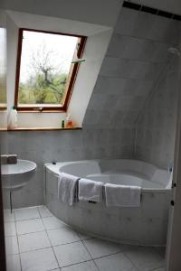 a bathroom with a tub and a sink and a window at Top Appartement 1 in Rosengarten/Hamburg in Rosengarten