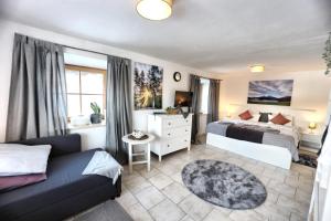 a bedroom with a bed and a couch in a room at Ferienwohnung Mariedei in Berchtesgaden