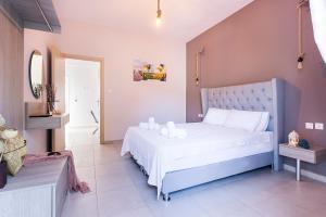 a bedroom with a bed with white sheets and white pillows at Sueño Luxury Apartments in Polychrono
