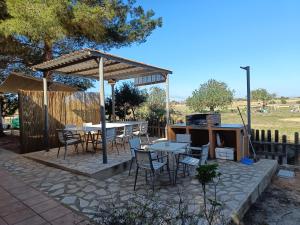 un patio con mesas, sillas y una parrilla en MAR I MONTANYA Formentera 2, en Sant Francesc Xavier