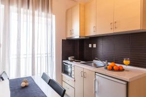 a kitchen with a sink and a plate of oranges on a counter at Sueño Luxury Apartments in Polykhrono +51 photos