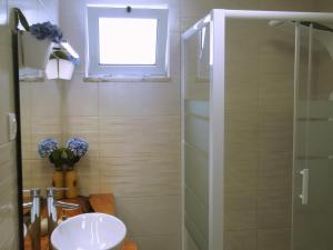 a bathroom with a sink and a shower with a window at Alo Baía São Lourenço in Santa Bárbara