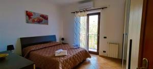 una camera con letto e porta di accesso a un balcone di Casa Pasitea a Taormina