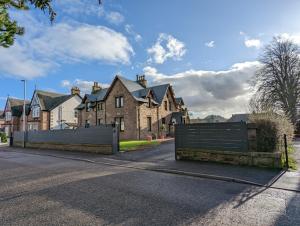 a house with two gates in front of a street at Cambeth Lodge in Inverness