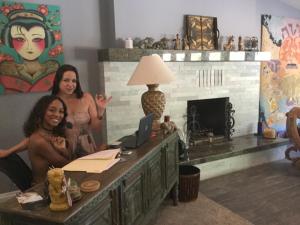 twee vrouwen in een kamer met een bureau en een laptop bij Sea Mountain Nude Resort & Spa Hotel - Adults Only in Desert Hot Springs