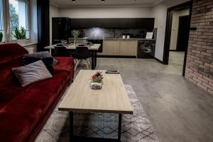 a living room with a red couch and a table at Apartament Chopin in Sanok