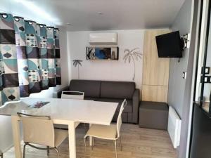 salon ze stołem, krzesłami i kanapą w obiekcie Charmant Mobil home avec Vue mer exceptionnelle w miejscowości Saint-Raphaël