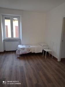 a bedroom with a bed and a table and two windows at Franca in Lonate Ceppino