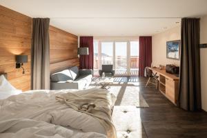 a bedroom with a bed and a living room at Naturhotel Outside in Matrei in Osttirol