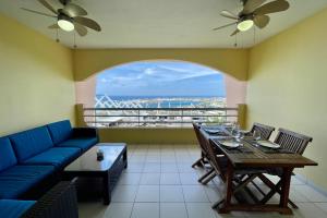 a living room with a blue couch and a table at Appartement Hana Iti breathtaking on the ocean at the entrance of Papeete in Papeete