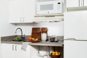 uma cozinha branca com um lavatório e um micro-ondas em InTown Suites Extended Stay San Antonio TX - Perrin Beitel Road em San Antonio