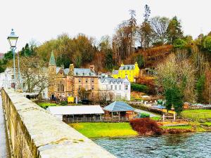 a town on a hill next to a body of water at River house in Birnam