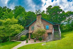 una casa con chimenea de piedra y escalera en Swiss Mountain Village en Blowing Rock