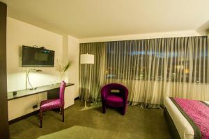 波哥大的住宿－Hotel City Bog Expo Museo，酒店客房,配有一张床、一张桌子和椅子