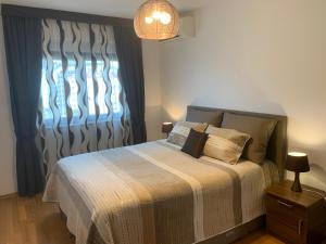 een slaapkamer met een bed met een deken en een raam bij Panorama Bar 2 bedroom in Bar +28 foto's