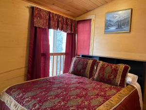a bedroom with a bed and a window with red curtains at Luna Bed & Breakfast in Grand Forks