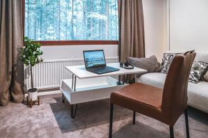 ein Wohnzimmer mit einem Schreibtisch und einem Laptop darauf in der Unterkunft Holiday Apartment Usva Studio II in Suomutunturi