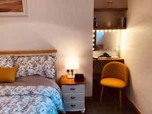 1 dormitorio con cama, lámpara y silla en Logan Home en Stornoway