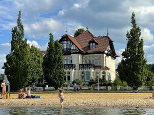 a house on the beach with people in the water at Apartment On The Beach, Schwerin in Schwerin