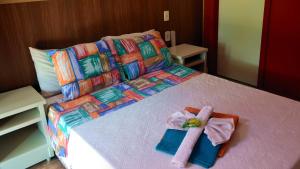 Una cama con toallas y una bata. en Serra da Luz, en Luminárias