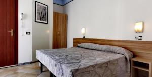 a bedroom with a bed and a wooden headboard at Hotel Nanni Garnì in Rimini