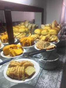 un montón de diferentes tipos de pasteles en platos en una mesa en Pousada Suítes Do Pelô en Salvador