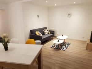 a living room with a couch and a table at Le cocon Dieppois - Appt spacieux avec parking privé in Dieppe