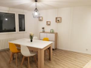 a dining room with a white table and chairs at Le cocon Dieppois - Appt spacieux avec parking privé in Dieppe