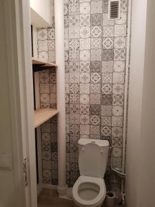 a bathroom with a toilet and a tile wall at Le cocon Dieppois - Appt spacieux avec parking privé in Dieppe