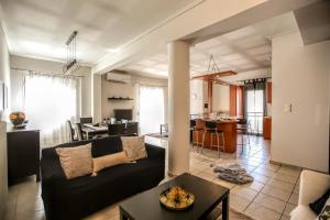 sala de estar con sofá negro y mesa en Grand Meteora Central Luxury Apartment en Kalabaka