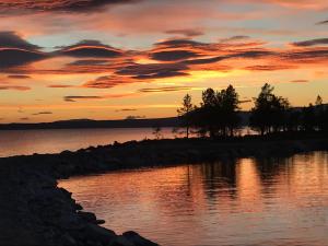 una puesta de sol sobre una pequeña isla en el agua en Båtstø Camping, en Elga