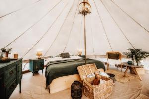 een slaapkamer in een tent met een bed en een stoel bij Hoopoe Glamping in Virpazar