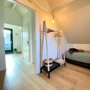 - une chambre avec un lit et des balançoires dans l'établissement Huisje Hygge - luxe bungalow met grote tuin, à Ewijk