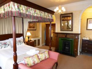 a bedroom with a canopy bed and a fireplace at The Bear Hotel in Devizes
