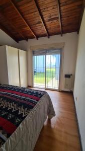 een slaapkamer met een bed en een groot raam bij Duplex frente al mar in Mar del Plata