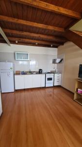 een grote keuken met witte apparatuur en een houten vloer bij Duplex frente al mar in Mar del Plata